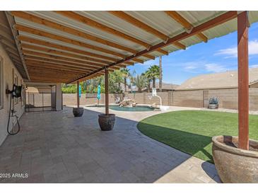Inviting backyard showcasing a covered patio area overlooking a pool and lush lawn at 4968 E Westchester Dr, Chandler, AZ 85249
