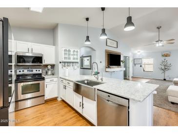 Modern kitchen featuring a spacious island with a stainless steel sink and appliances, and white cabinets at 11822 W Softwind Dr, Sun City, AZ 85373