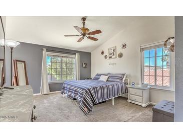 Bright bedroom featuring a ceiling fan, two windows, and a neatly made bed at 15846 S 33Rd Pl, Phoenix, AZ 85048