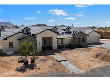 Charming home with dormer windows, paver driveway, and white and stone facade at 3323 N 81St St, Mesa, AZ 85207