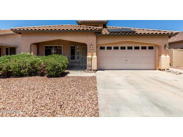 Charming single-story home with a tile roof, low-maintenance landscaping, and a two-car garage at 12238 W Monroe St, Avondale, AZ 85323