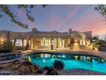 Beautiful backyard pool and spa with lush landscaping creating a private oasis for relaxation at 43 E Desert Hills Dr, Phoenix, AZ 85086