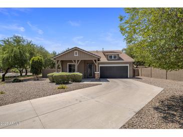 Charming single-story home featuring a well-manicured yard and a two-car garage in a Gathering-friendly neighborhood at 865 E Rojo Ct, Gilbert, AZ 85297