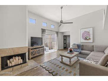 Bright living room features a fireplace, high ceilings, and a balcony with sliding glass doors at 11333 N 92Nd St # 2049, Scottsdale, AZ 85260
