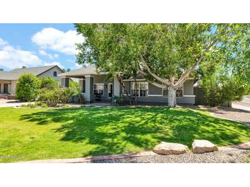 Charming single-story home featuring a lush lawn and mature shade tree at 139 W Granada Rd, Phoenix, AZ 85003