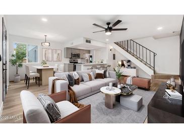 Bright living room showcasing a spacious layout, modern decor, and seamless flow to the kitchen and staircase at 2625 W Ocotillo Rd # 4, Phoenix, AZ 85017