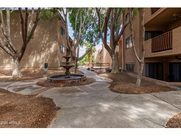 Community courtyard with fountain, mature trees, and walking paths between buildings at 3031 N Civic Center Plz # 340, Scottsdale, AZ 85251