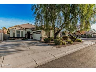 Inviting single-story home featuring a large front yard, desert landscaping, and a two-car garage at 3080 E Palmdale Ln, Gilbert, AZ 85298