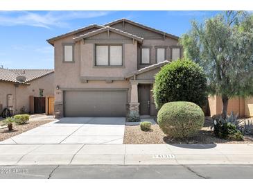 Charming two-story home with a well-manicured front yard and inviting curb appeal on a sunny day at 41311 W Elm Dr, Maricopa, AZ 85138