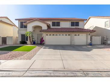 Charming two-story home with a three-car garage, desert landscaping, and a red tile roof at 5754 W Larkspur Dr, Glendale, AZ 85304