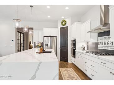 Modern kitchen showcasing a spacious island, sleek stainless steel appliances, and lots of storage at 22848 N 98Th Dr, Peoria, AZ 85383