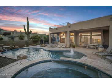 Relaxing backyard pool and spa area with a waterfall feature and comfortable lounge chairs at 30813 N 138Th St, Scottsdale, AZ 85262