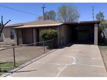 Charming exterior view of a single-story home with a covered carport and cracked driveway at 112 S 28Th Dr, Phoenix, AZ 85009