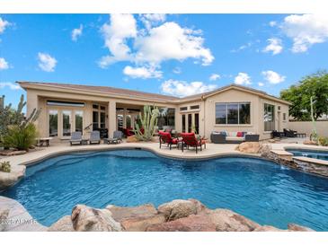 Stunning pool area featuring a hot tub, patio seating and native landscaping at 11448 E Blue Sky Dr, Scottsdale, AZ 85262