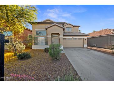 Attractive two-story home featuring manicured landscaping, neutral tones, and an attached two-car garage at 2206 S 114Th Ln, Avondale, AZ 85323