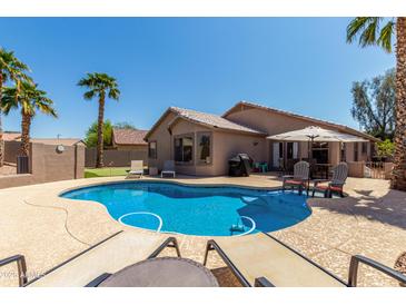 Relaxing backyard pool area with lounge chairs and mature landscaping creating a private oasis at 24806 W Hidalgo Dr, Buckeye, AZ 85326