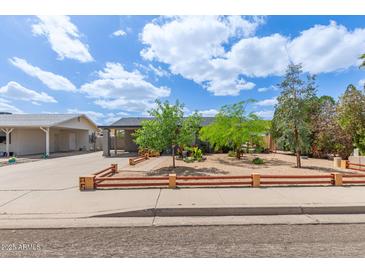 Charming single-story home with mature trees and a landscaped front yard at 313 W Utopia Rd, Phoenix, AZ 85027
