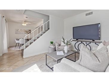 Bright living room with staircase, modern decor, and comfortable seating arrangement at 3511 E Baseline Rd # 1214, Phoenix, AZ 85042