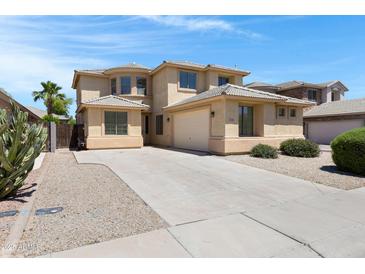 Inviting two-story home showcasing desert landscaping and a spacious concrete driveway leading to an attached two-car garage at 43860 W Roth Rd, Maricopa, AZ 85138
