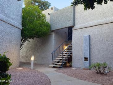 Charming building exterior with walkway, blue stair railing and desert landscaping at 4444 E Paradise Village N Pkwy # 251, Phoenix, AZ 85032