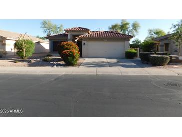 Charming home featuring a well-maintained front yard with desert landscaping and a two-car garage at 4613 E Walnut Rd, Gilbert, AZ 85298