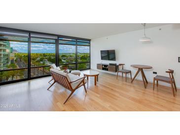 Bright living room with wood floors, modern furniture, and floor-to-ceiling windows with city views at 4808 N 24Th St # 806, Phoenix, AZ 85016