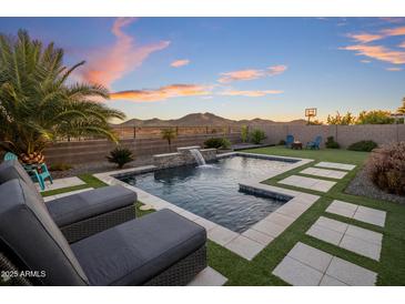 Resort-style backyard pool with water feature, mountain views, basketball hoop, and lounge seating at 537 E Balao Dr, Phoenix, AZ 85085