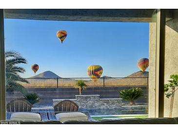 Stunning view from home featuring hot air balloons over desert landscape and pool at 537 E Balao Dr, Phoenix, AZ 85085