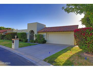 Charming single-story home with a red tile roof, arched entry, and well-manicured landscaping at 5718 N 72Nd Pl, Scottsdale, AZ 85250