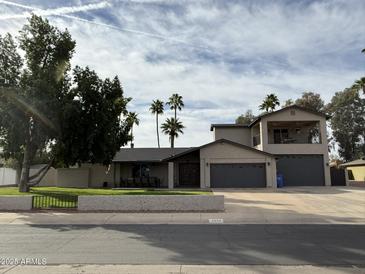 Charming home featuring mature landscaping, palm trees, 2-car garage, and a private second story balcony at 5751 E Ludlow Dr, Scottsdale, AZ 85254