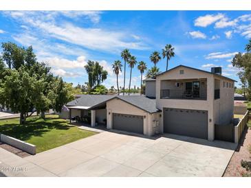 A beautiful two-story home with three-car garage, an upstairs balcony, and mature landscaping at 5751 E Ludlow Dr, Scottsdale, AZ 85254