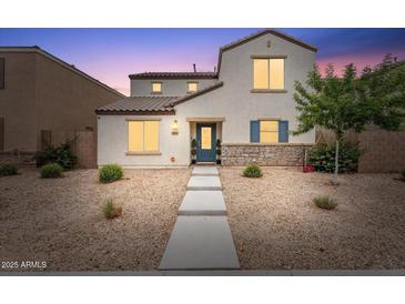 Charming two-story home featuring stone accents, low-maintenance landscaping, and a inviting blue front door at 8043 W Albeniz Pl, Phoenix, AZ 85043