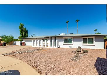 Charming single-story home featuring a two car garage and a desert landscape at 8714 E Mackenzie Dr, Scottsdale, AZ 85251
