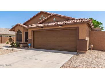 Charming single-story home with a well-maintained front yard, desert landscaping, and a two-car garage at 13145 W Cambridge Ave, Goodyear, AZ 85395