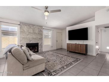 Inviting living room boasts a fireplace, ceiling fan and neutral decor throughout the home at 19202 N 14Th St, Phoenix, AZ 85024