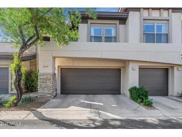 Exterior of home featuring a two-car garage, stone accents, and desert landscaping at 20121 N 76Th St # 1019, Scottsdale, AZ 85255