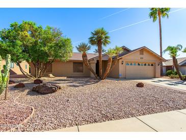 Charming single-story home featuring a two-car garage, desert landscaping, and mature palm trees at 2757 Leisure World --, Mesa, AZ 85206