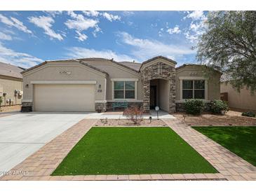 Charming single-story home with stone accents, manicured landscaping, and a well-maintained lawn at 30213 W Fairmount Ave, Buckeye, AZ 85396