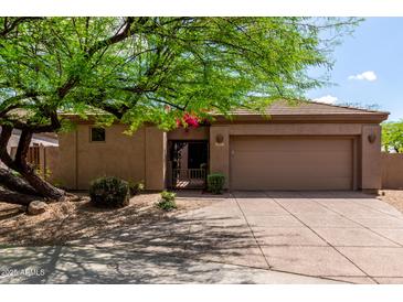 Tan home with a tile roof, gravel landscaping, and a green desert tree in front at 32627 N 70Th St, Scottsdale, AZ 85266