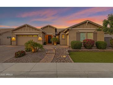 Inviting single-story home with well-manicured landscaping and a charming walkway at dusk at 3552 E Dogwood Dr, Chandler, AZ 85286
