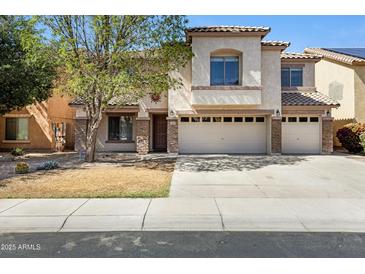 Charming two-story home featuring stucco finish, tile roof, a three-car garage, and well-maintained landscaping at 43232 W Magnolia Rd, Maricopa, AZ 85138