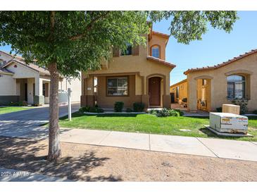 Charming tan two-story home with a well-maintained lawn, sidewalk, and mature landscaping for enhanced curb appeal at 5323 E Hopi Ave, Mesa, AZ 85206