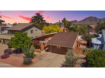 Charming home with beautiful landscaping and desert foliage, all set against a mountain backdrop at sunset at 5528 E Virginia Ave, Phoenix, AZ 85008