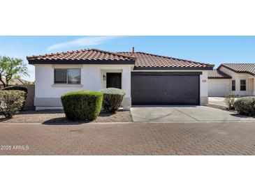 Charming single-story home featuring a dark garage door and low maintenance desert landscaping at 6108 S Wilson Dr, Chandler, AZ 85249
