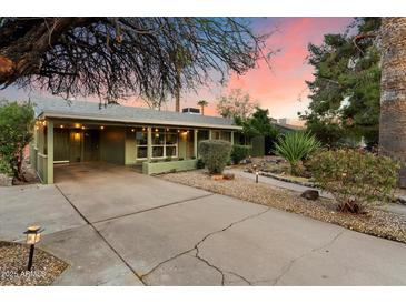 Charming home exterior with a spacious driveway and well-maintained landscaping at sunset at 7813 N 17Th Dr, Phoenix, AZ 85021