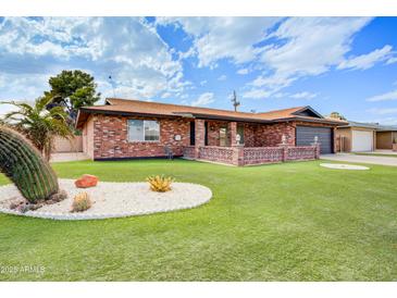 Charming brick home featuring manicured lawn and desert landscaping in a tranquil neighborhood setting at 858 S Portland --, Mesa, AZ 85206