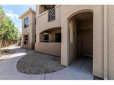 Inviting condo exterior featuring an arched entry, neutral stucco, and well-maintained landscaping at 9550 E Thunderbird Rd # 149, Scottsdale, AZ 85260