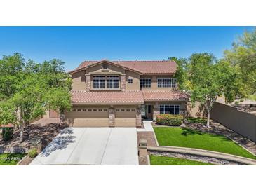 Stunning two-story home boasts a three-car garage, well-manicured lawn, and desert landscaping at 9570 W Quail Track Dr, Peoria, AZ 85383