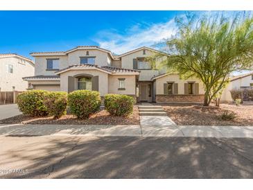 Charming two-story home with neutral stucco, stone accents, groomed bushes and mature tree at 1779 E Kaibab Dr, Chandler, AZ 85249
