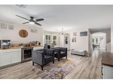 Open living room featuring a wet bar, modern light fixture, and neutral color palette at 3551 E Mead Dr, Gilbert, AZ 85298